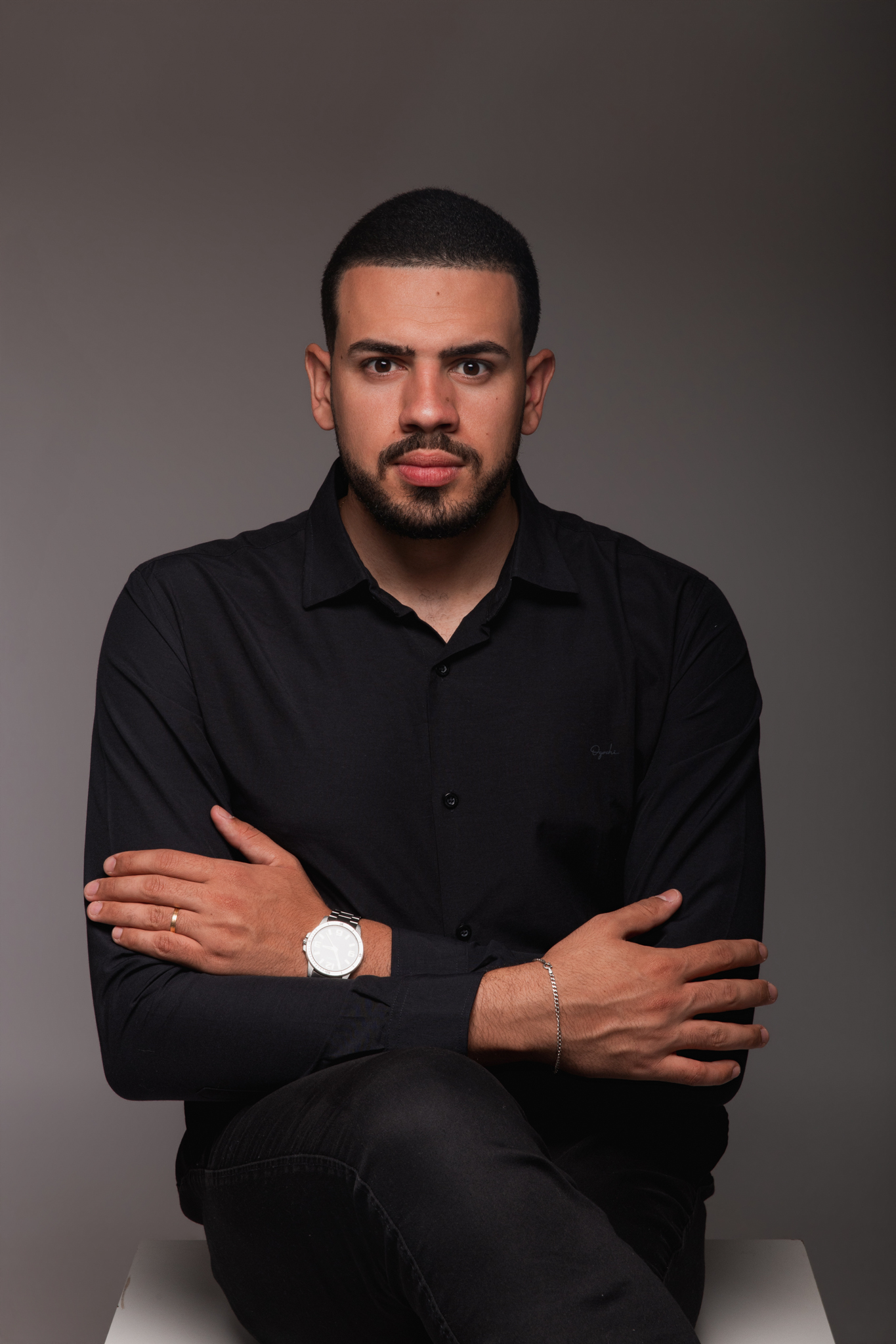 Retrato de Tomaz Machado, de camisa preta e braços cruzados